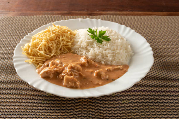istock Chicken stroganoff accompanied with rice, salad and potato straw. 1401817450