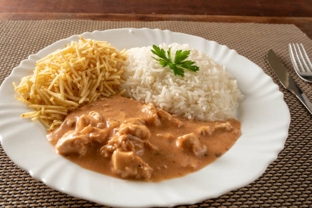 istock Chicken stroganoff accompanied with rice, salad and potato straw. 1401817539