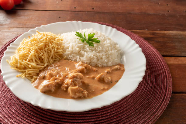 istock Chicken stroganoff accompanied with rice, salad and potato straw. 1401817558