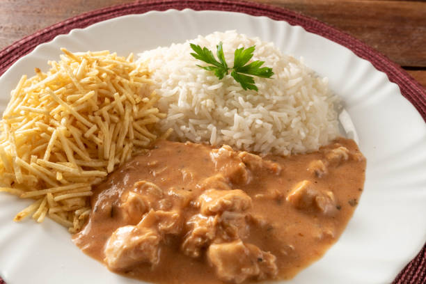 istock Chicken stroganoff accompanied with rice, salad and potato straw. 1401817560