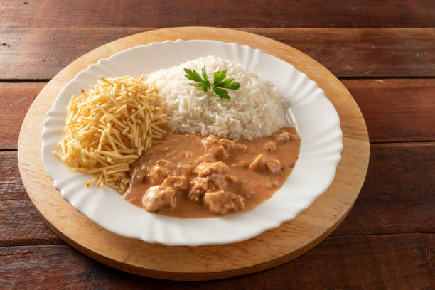 istock Chicken stroganoff accompanied with rice, salad and potato straw. 1401817585