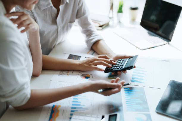 istock financial, Brainstorming, Data Analysis, Planning, Marketing and Accounting, Economist using calculator to calculate investment documents with partners on profit taking to compete with other companie. 1401822210