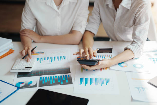 istock financial, Brainstorming, Data Analysis, Planning, Marketing and Accounting, Economist using calculator to calculate investment documents with partners on profit taking to compete with other companie. 1401822327