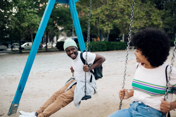 istock Happy couple having fun swinging on a playground. 1401823127