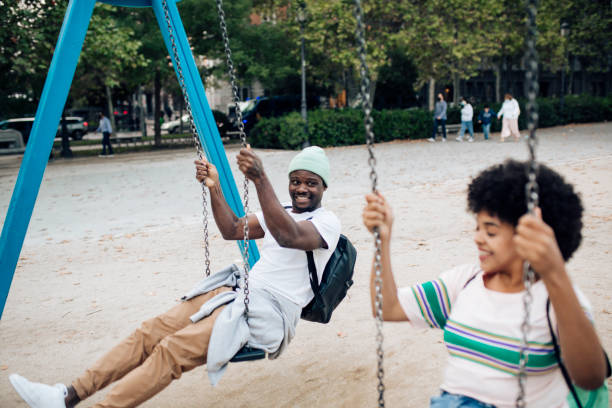 istock Happy couple having fun swinging on a playground. 1401823133