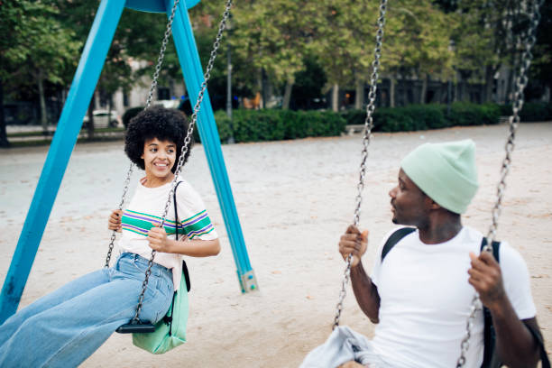 istock Happy couple having fun swinging on a playground. 1401823134