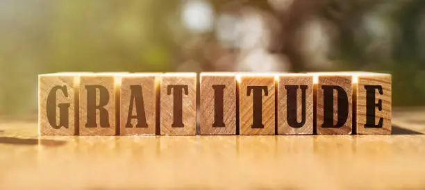 Photo of gratitude word written on wood block. gratitude text on wooden table for your desing, concept.