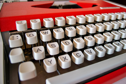 Red typewriter with white keys closeup shot