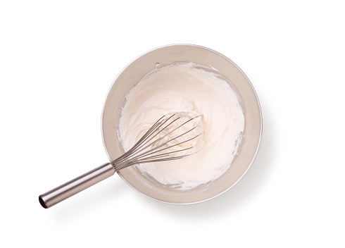 whipped cream and whisk in bowl with clipping path.