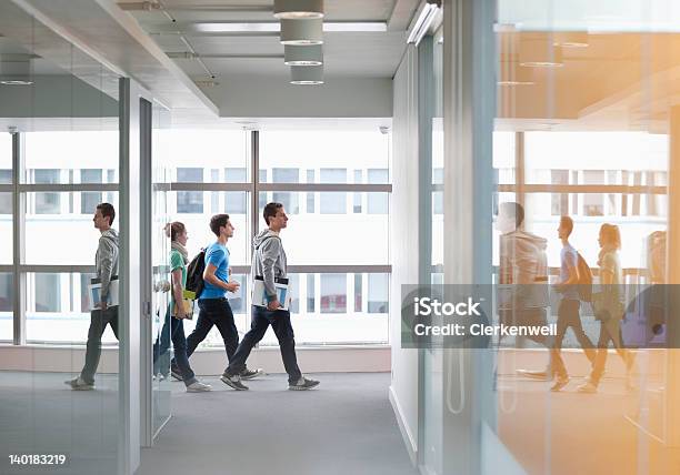 University Students Walking In Corridor Stock Photo - Download Image Now - University, Student, Corridor