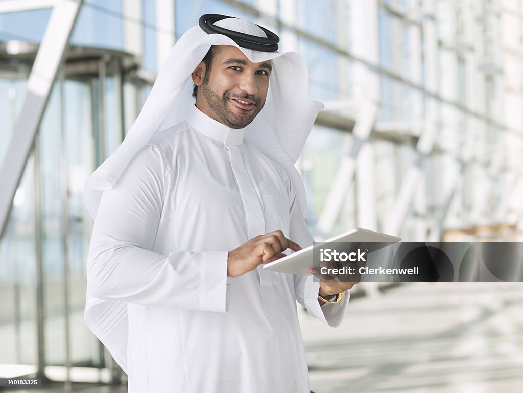 Портрет улыбающегося бизнесмена с помощью цифрового планшета в Арафатка - Стоковые фото Средневосточная этническая принадлежность роялти-фри
