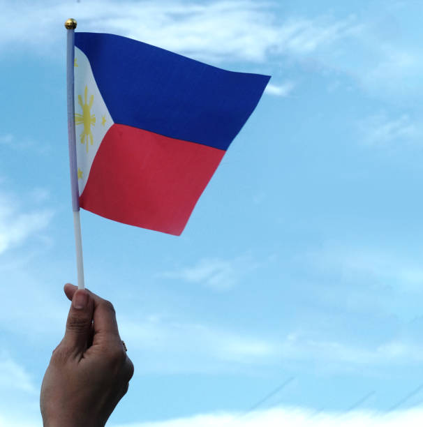 istock A hand waves a Philippine flag against a blue sky 1401834992