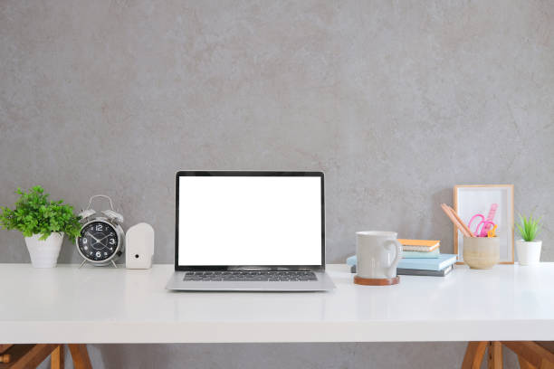istock Computer laptop, stationery, coffee cup and houseplant on white table. Empty screen for your text message or information content. 1401844947