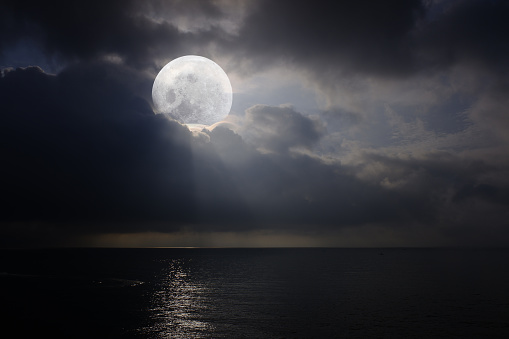 Romantic and scenic panorama with full moon on the sea at night.
