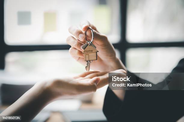 A Home Rental Company Employee Is Handing The House Keys To A Customer Who Has Agreed To Sign A Rental Contract Explaining The Details And Terms Of The Rental Home And Real Estate Rental Ideas Stock Photo - Download Image Now