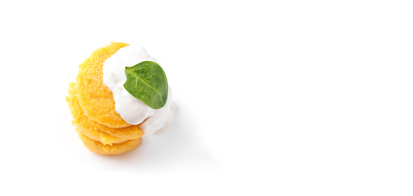 Pancakes fried polenta on a white background isolated. Pancakes stacked one on top of the other pancakes with macarella cheese and spinach. Top view. Empty space. Isolated