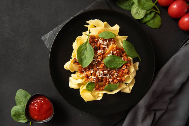 istock Pasta with sauce and basil on a dark background. Top view 1401852573