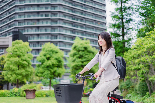 A busy businesswoman commuting to work on a shared bicycle