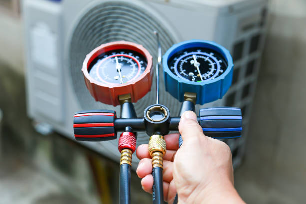 Technician checking air conditioning operation, detecting refrigerant leaks. stock photo