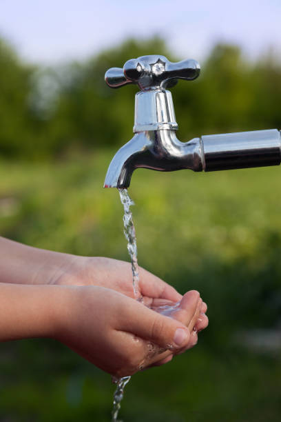 istock boy washes his hand under the faucet in garden 1401867128