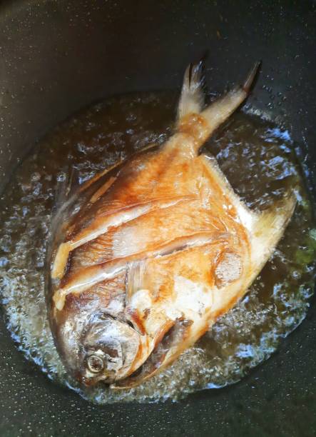 Pan Fried Pomfret fish - food preparation. stock photo