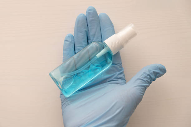 istock Sanitizer bottle in human hands in blue elastic gloves 1401871845