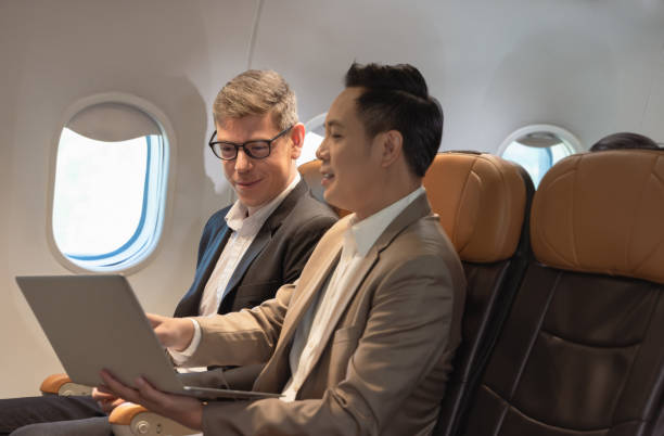 istock Two business people working together on laptop during flight 1401877305