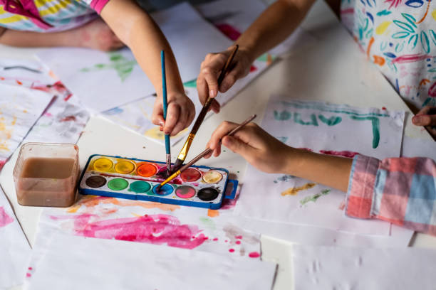 istock Close up children hands holding paintbrush 1401878634