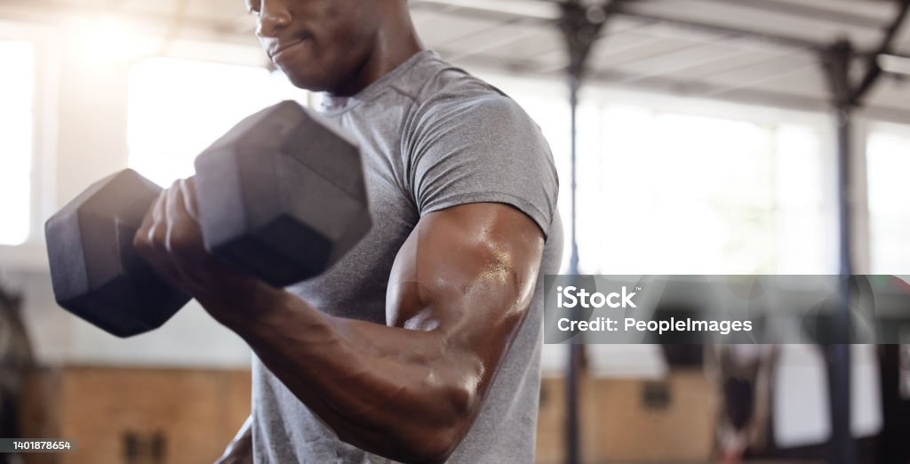 Unknown african american athlete lifting dumbbell during bicep curl arm workout in gym. Strong, fit, active black man training with weight in health and sports club. Weightlifting exercise routine Bicep Stock Photo