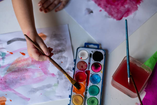 istock Close up hand holds paintbrush 1401878718