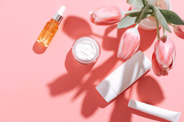istock Spring cosmetic flat lay frame with flowers on pink, copy space, top view. 1401878774