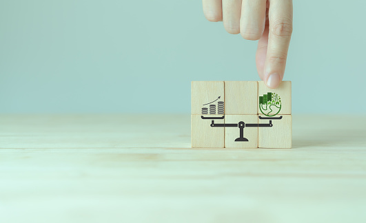 Sustainable development concept. Weight scale with green planet and money growth. Green business culture, environmental sustainability policy. ESG, sustainable business, positive impact on the world.