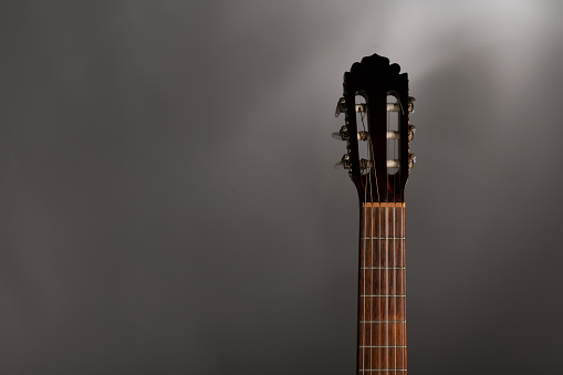 classical guitar fretboard and machine head on a grey background eith copy space