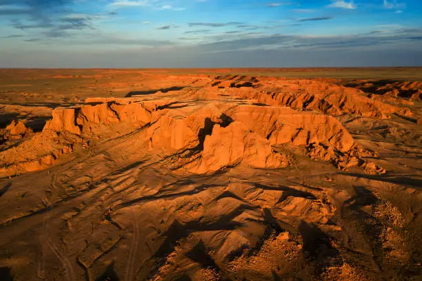 Aerial view of the Bayanzag flaming cliffs at sunset in Mongolia, found in the Gobi Desert"n