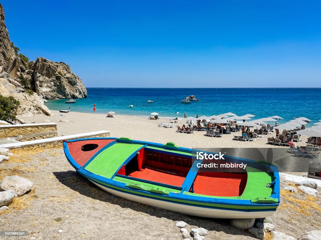 Boat at idyllic beach Kira Panagia, Karpathos island, Greece Boat at idyllic beach Kira Panagia on Karpathos, Greece. Bay of Water Stock Photo
