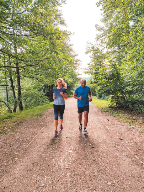 istock Mature Mixed Race Couple Jogging Outdoors On A Fresh Summer Morning 1401881438
