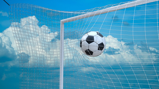 Soccer ball flying in the net. Cloudly bg