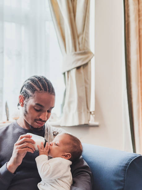 istock Contented baby being fed from bottle by modern father 1401885388