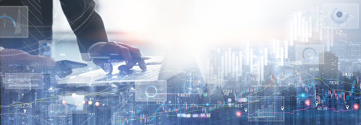 Double exposure of businessman working on laptop computer and the city with financial graph, economic growth chart, forex trading for business and financial technology background