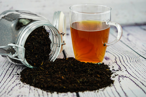 Herbal tea on dark background. Woman holding tea cup.