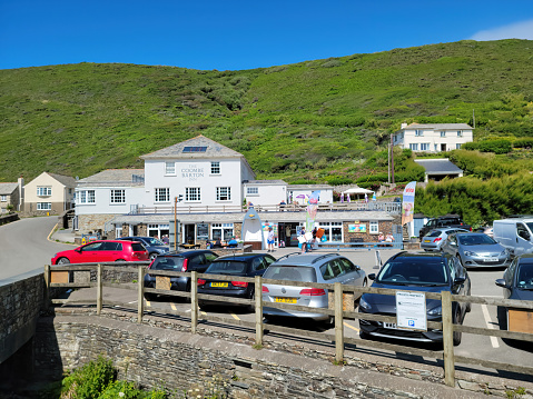 Coombe Barton Inn at Crackington Haven, Cornwall, England, UK.  There are cars parked in the sunshine in front of the Inn.