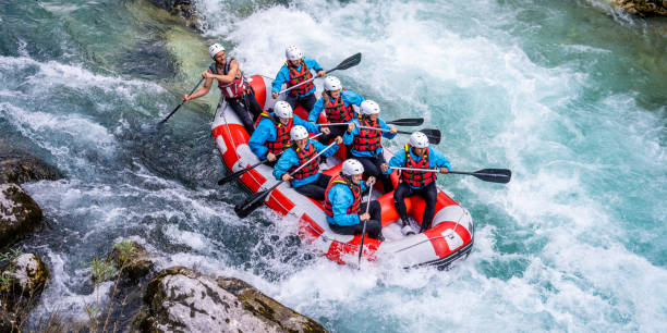 Friends rafting in river Elevated view of friends holding oar and rafting in river. rafting stock pictures, royalty-free photos & images