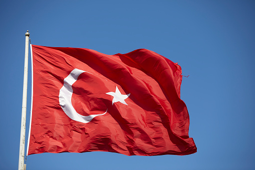 Red turkish flag on blue sky at a windy day