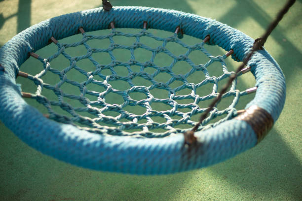 Round swings for children. Swings on ropes. Details of playground.