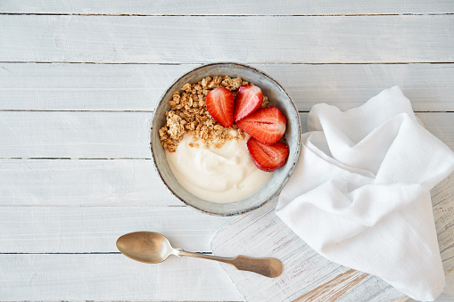 Granola with curd cheese and strawberries in a bowl