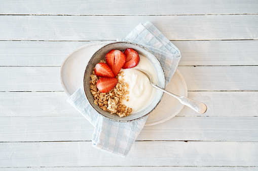 Granola with curd cheese and strawberries in a bowl