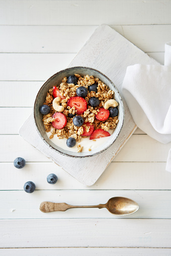 various bowls of breakfast cereal with milk and berries isolated on white background