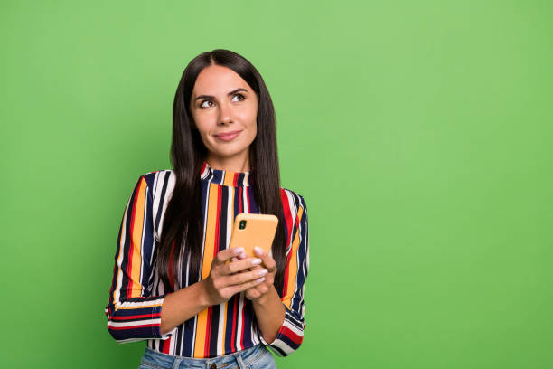 istock Portrait of attractive minded cheerful girl using device browsing thinking copy space ad isolated over green pastel color background 1401897077