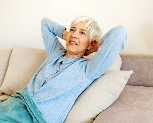 istock Relaxed serene mature woman lounge on comfortable sofa at home 1401897328