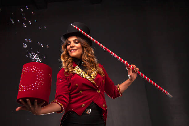 Female magician makes with soap bubbles show, an illusionist Female magician with box and magic cane makes with soap bubbles show, an illusionist in theatrical clothes and hat. Woman actress in stage costume. Concept of theatrical performance and fun show stage actress stock pictures, royalty-free photos & images